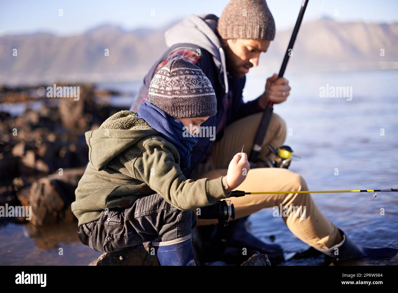 Come un padre, come un figlio, un ragazzino carino che pesca con il padre sul mare. Foto Stock