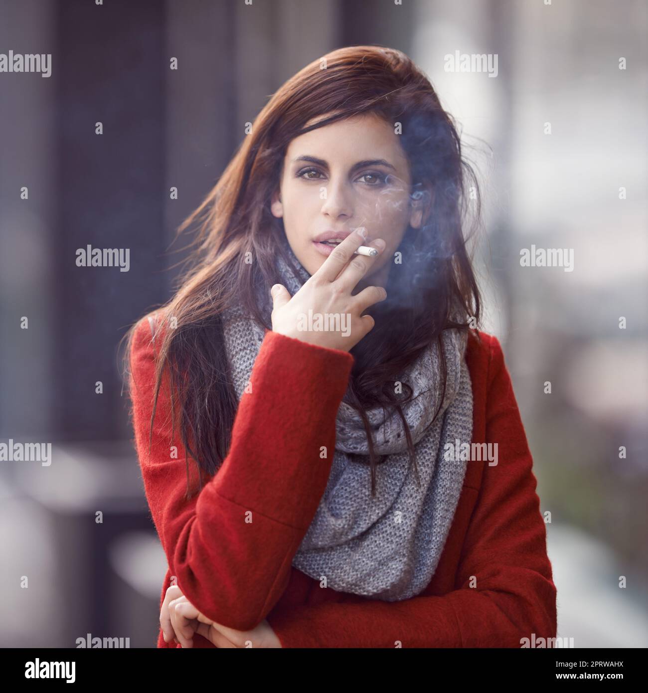 Quando la voglia chiama. Ritratto di una giovane donna bella e alla moda che fuma una sigaretta in un ambiente urbano. Foto Stock