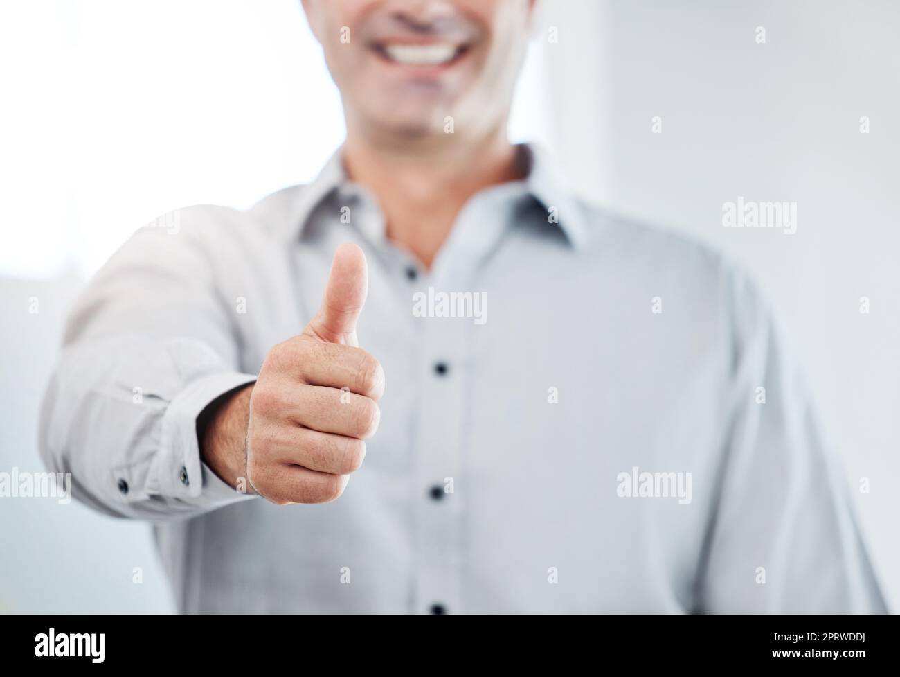 Un uomo d'affari si alza il pollice, vota o ama le emoji della mano per promuovere, avere successo o fidarsi. Un ringraziamento professionale, sì o un segno di supporto o un'icona per un accordo, una revisione sui social media o un lavoro soddisfacente Foto Stock