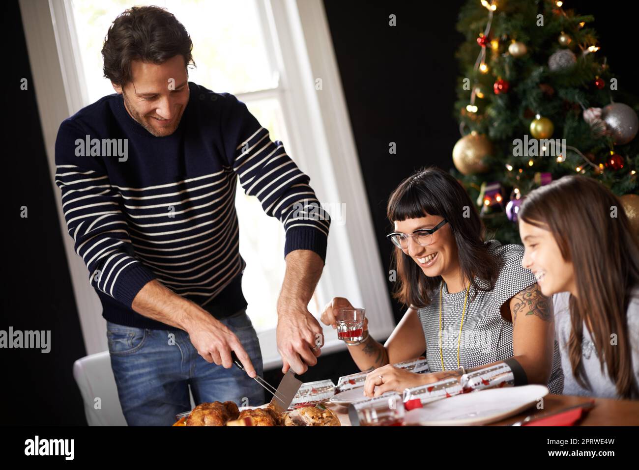 Spero che tutti siano affamati. Un padre che taglia l'uccello di natale. Foto Stock