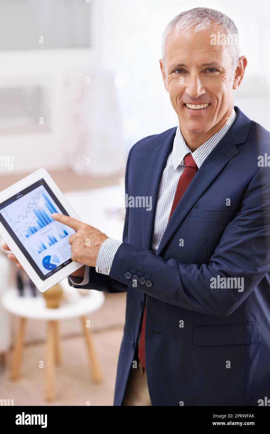 Può u credere quanto grande questi numeri assomigliano. Un uomo d'affari maturo che gestura felicemente al suo tablet. Foto Stock
