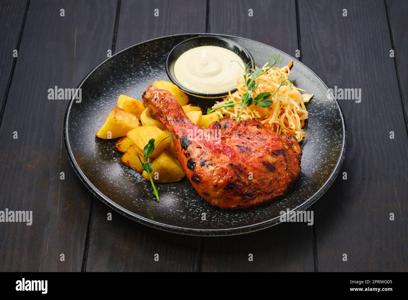 Cosce di pollo arrosto con spicchi di patate e cavolo sottaceto Foto Stock