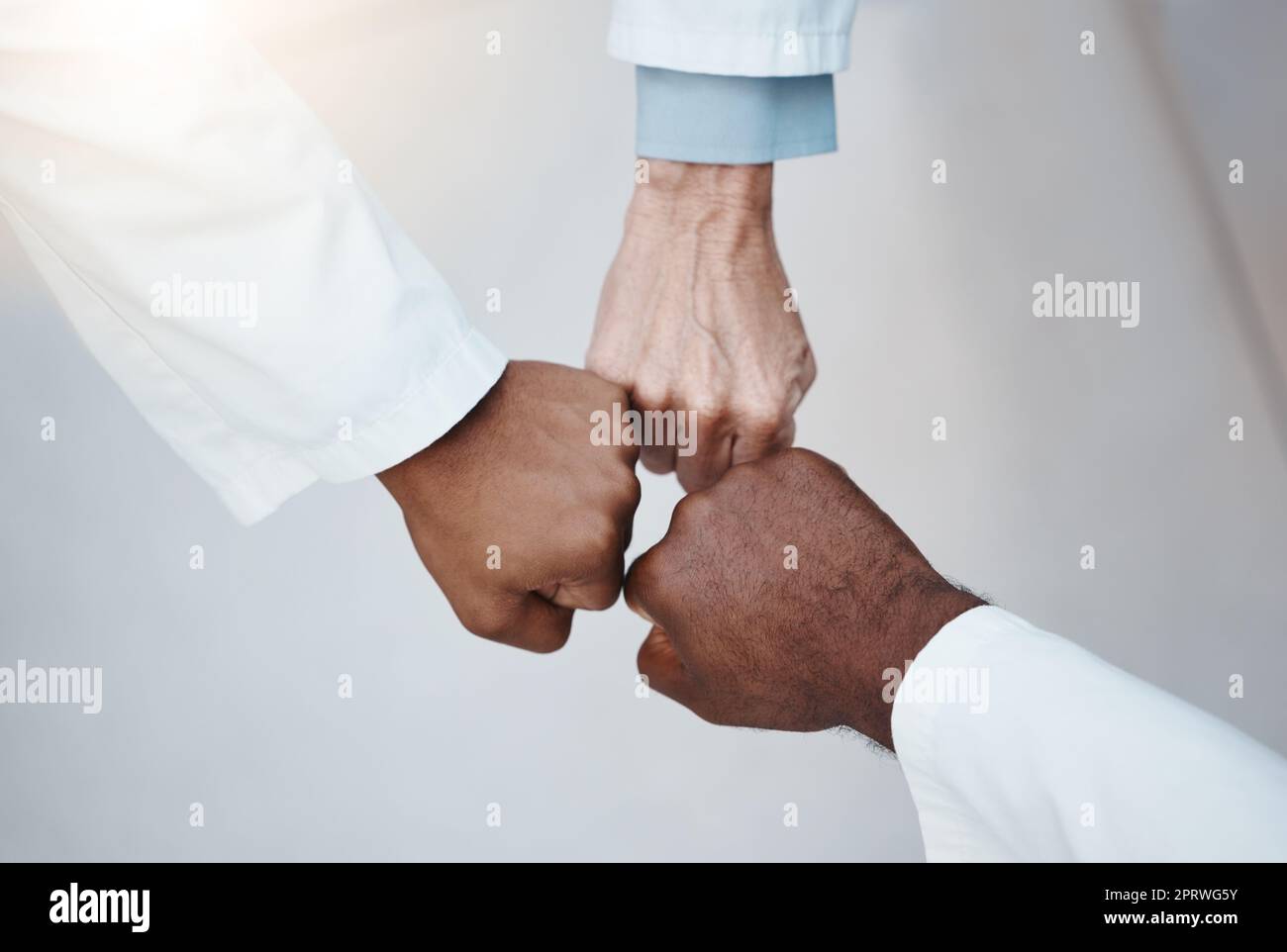 Fiducia, lavoro di squadra e pugno a mano insieme in solidarietà con l'etica medica sul posto di lavoro. Supporto di diverse persone professionali del lavoro nell'organizzazione con rispetto e lealtà. Foto Stock