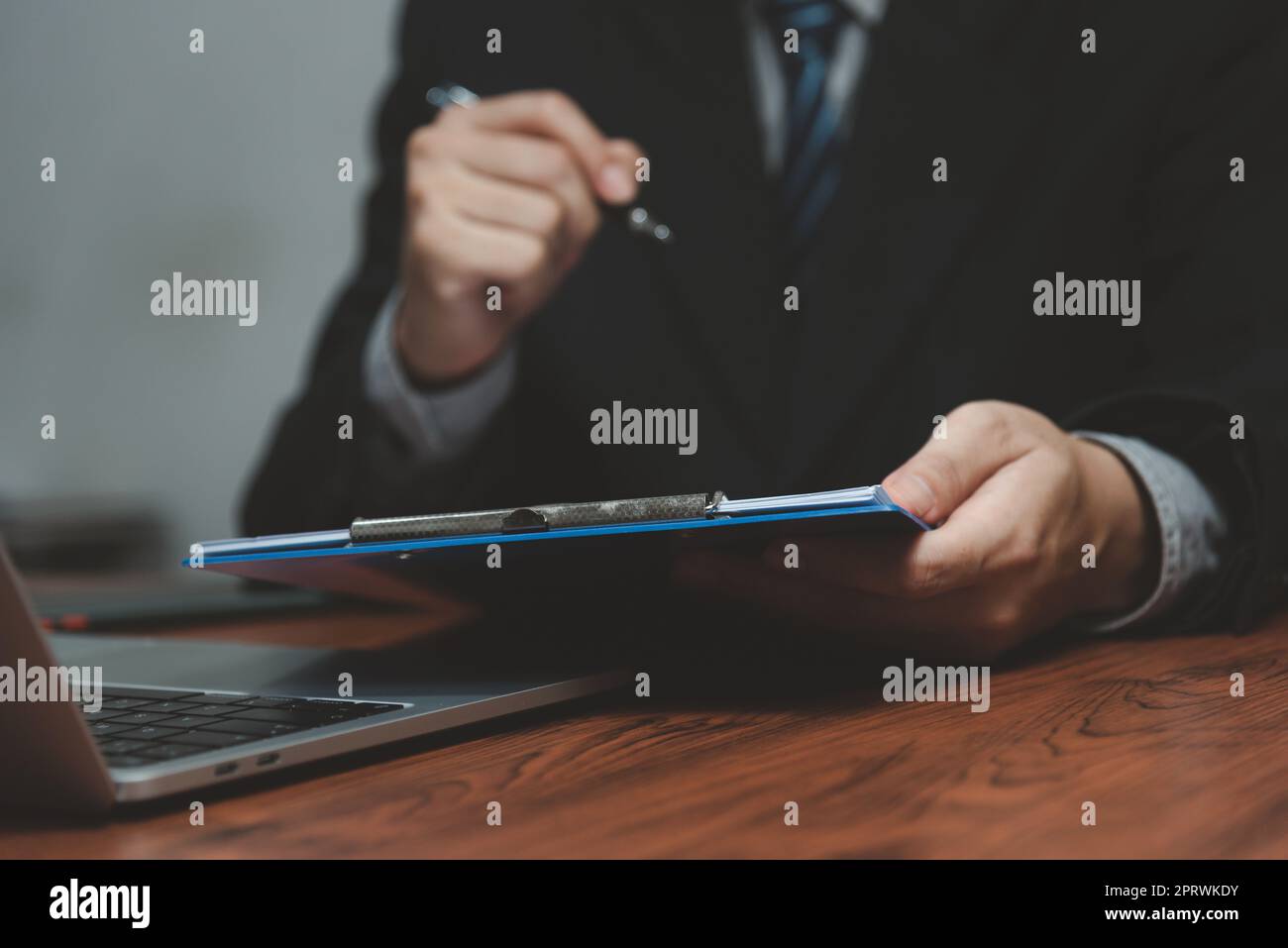 uomo d'affari che tiene il documento della firma della penna sulla clipboard alla scrivania. Informazioni commerciali avvocato di assicurazione e concetto di lavoro. Foto Stock
