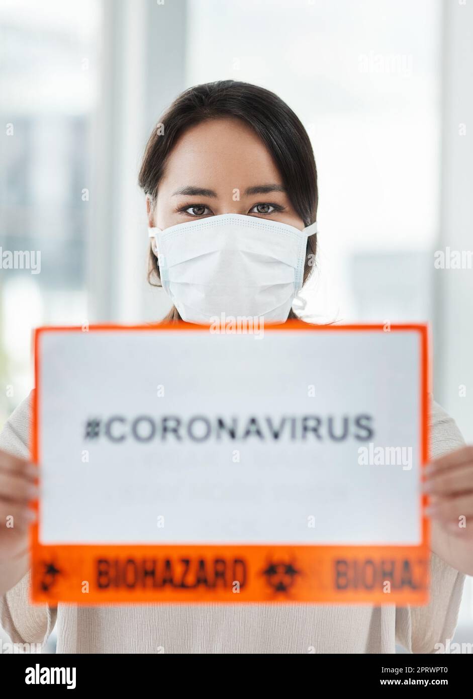 Il suo giro è come un hashtag sui social media, una donna che tiene un cartello con CORONAVIRUS su di esso. Foto Stock