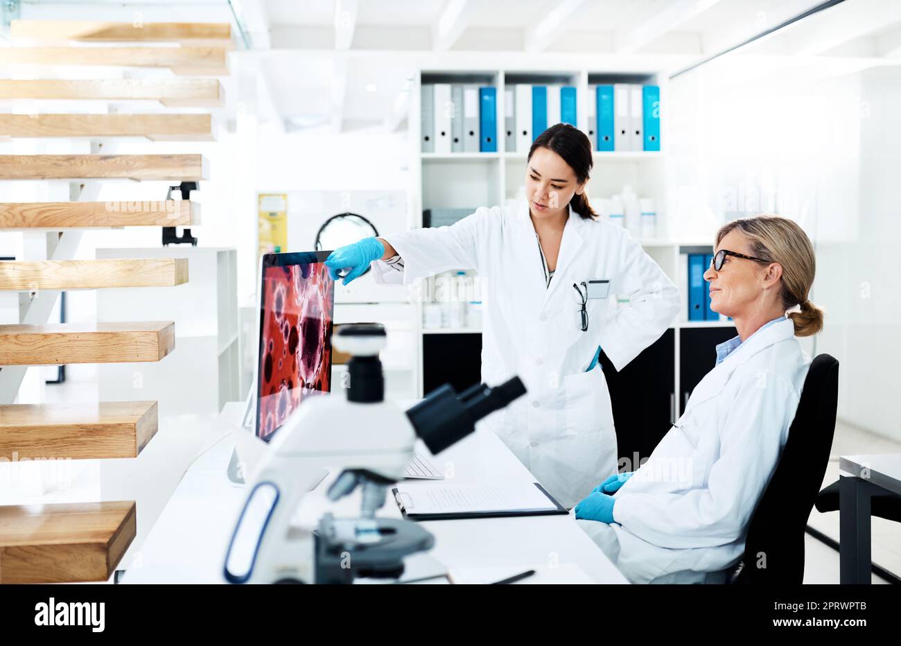 La ricerca clinica aiuta a tradurre le scoperte mediche in trattamenti di lavoro, due scienziati che lavorano insieme su un computer in un laboratorio. Foto Stock