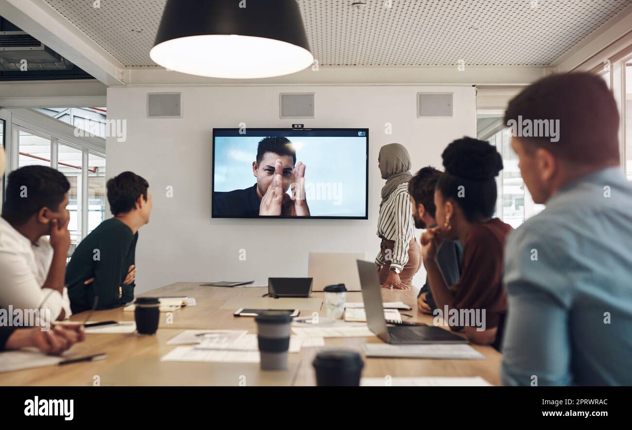 Un gruppo di colleghi di lavoro si è riunito nella sala riunioni per una videoconferenza. Foto Stock