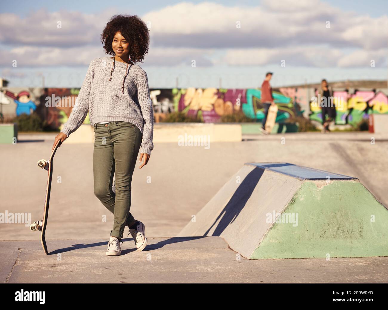 Perché camminare quando si può pattinare. Una giovane donna fuori skateboard in città. Foto Stock