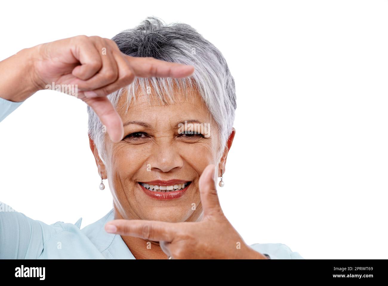 Stile di vita maturo. Studio di una donna matura che incornicia il viso con le dita isolate sul bianco. Foto Stock