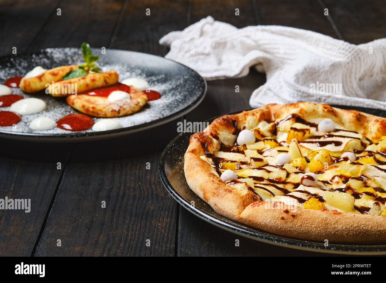 Torta dolce con banana, arancia, mirtilli rossi e sciroppo al caramello Foto Stock