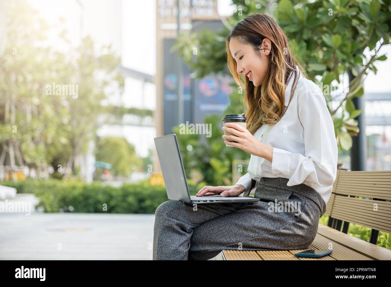 business giovane donna che lavora laptop esterno edificio aziendale esterno Foto Stock