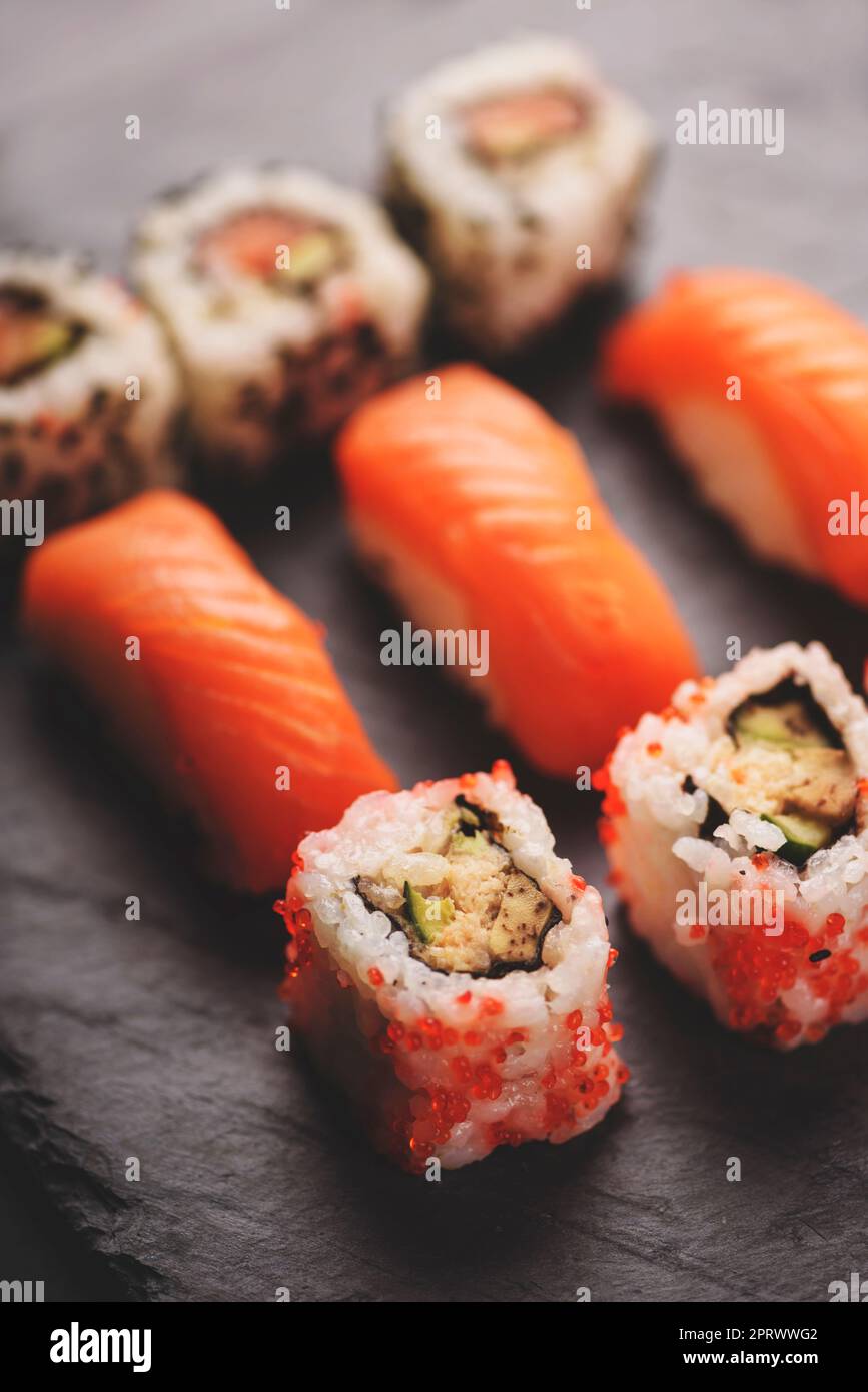 Sushi giapponese su piatto di pietra nera Foto Stock