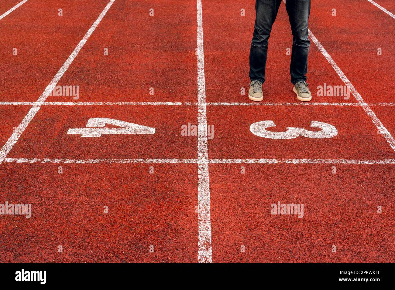 Uomo in piedi alla linea di partenza sul punto di partenza numero tre Foto Stock
