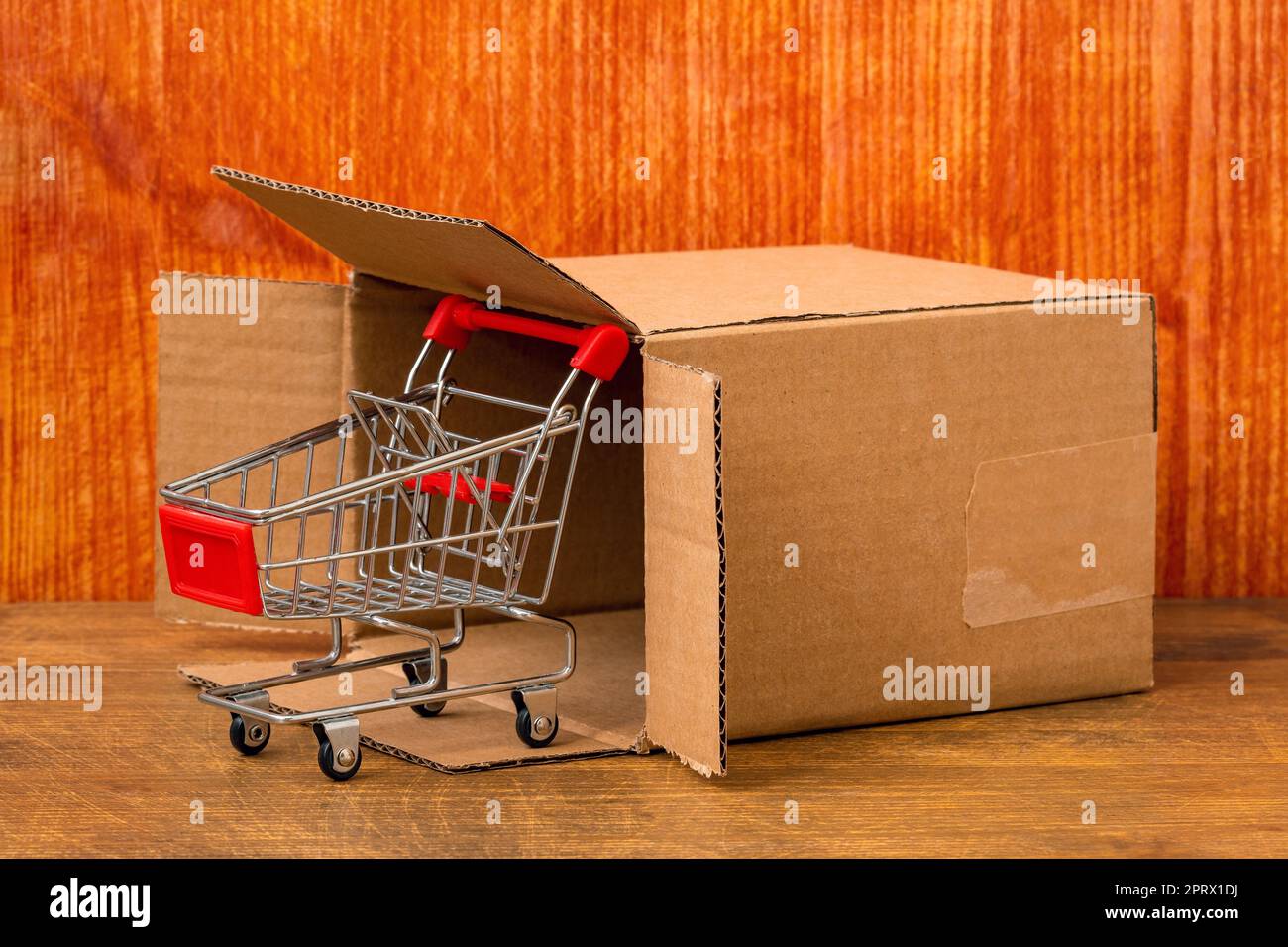 Carrello della spesa vuoto che esce dalla confezione di cartone Foto Stock