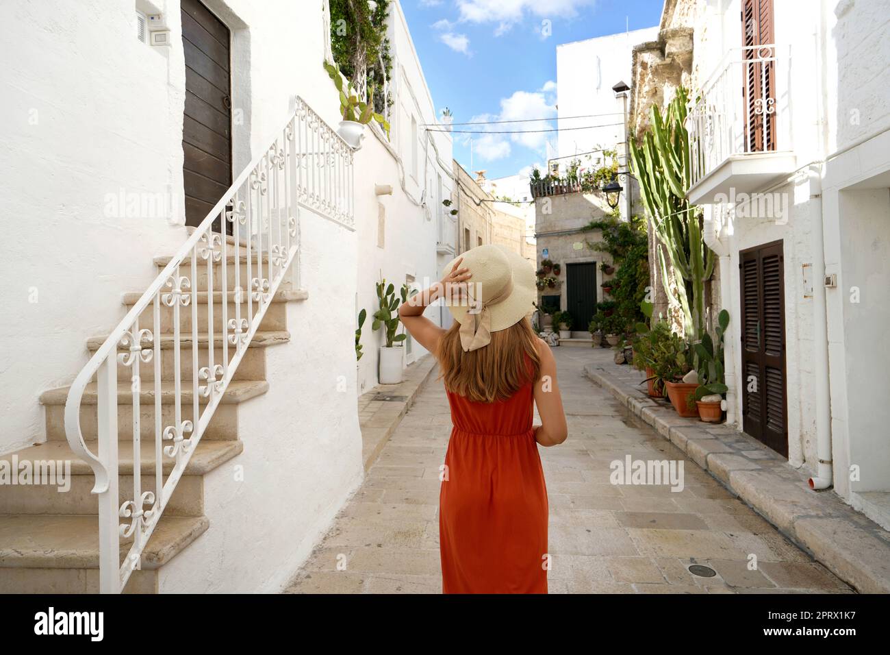 Giovane donna turistica che cammina nel centro storico di Monopoli in Puglia, Italia Foto Stock