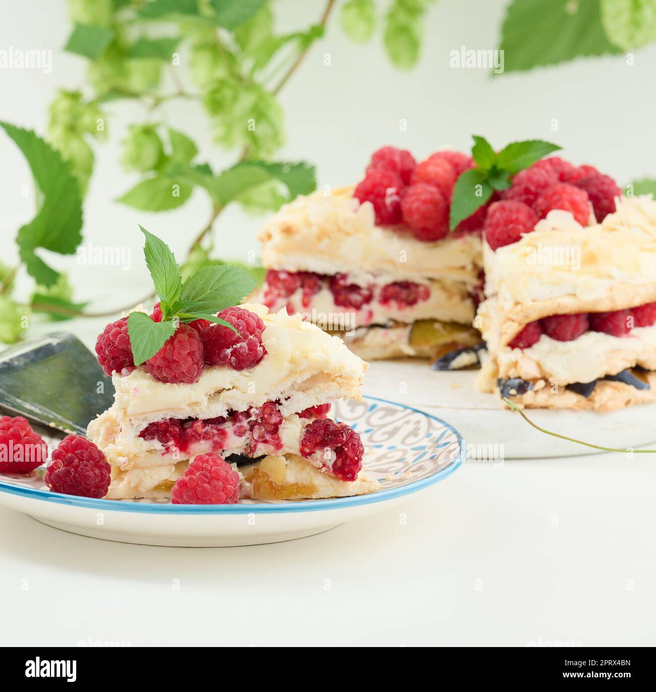 Torta di meringa rotonda con lamponi freschi su sfondo bianco, Pavlova dessert Foto Stock