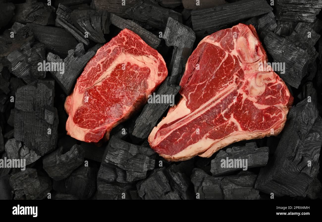 Cucinare bistecche di manzo crude su carbone Foto Stock