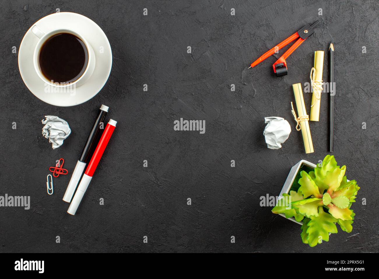 vista dall'alto tazza di tè rosso e nero marcatori clip raccoglitore bussole su sfondo nero con spazio libero Foto Stock