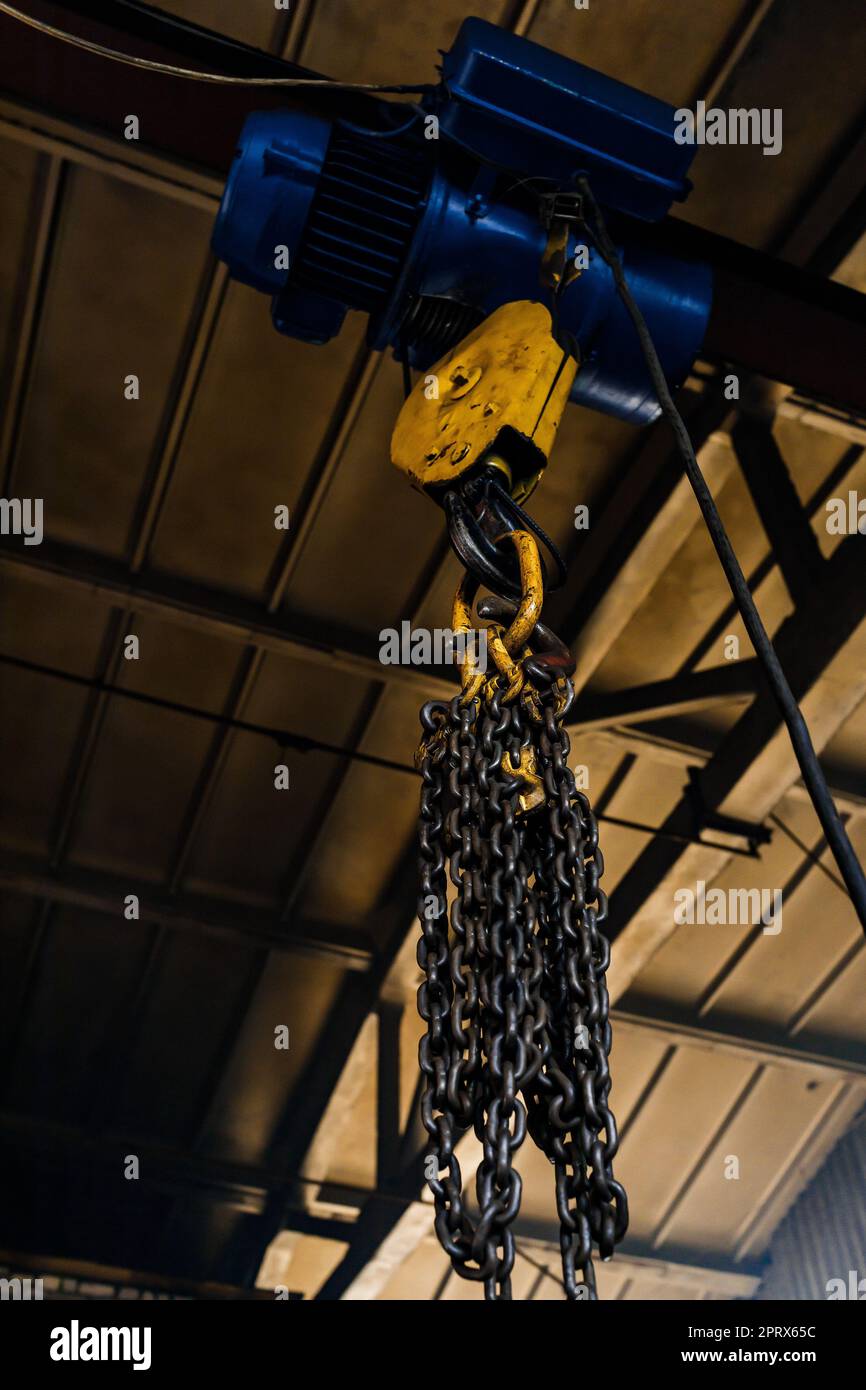 gancio a catena in acciaio per paranco elettrico. sfondo industriale. Gancio per gru di fabbrica Foto Stock