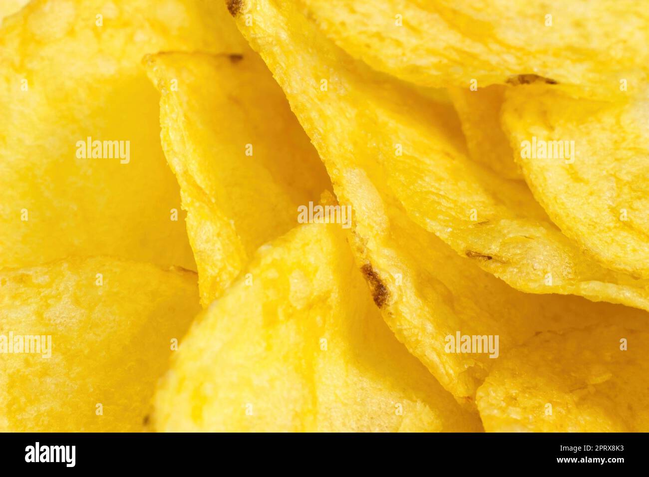 Patatine sottili di colore giallo brillante come primo piano del cibo testurizzato. Foto Stock