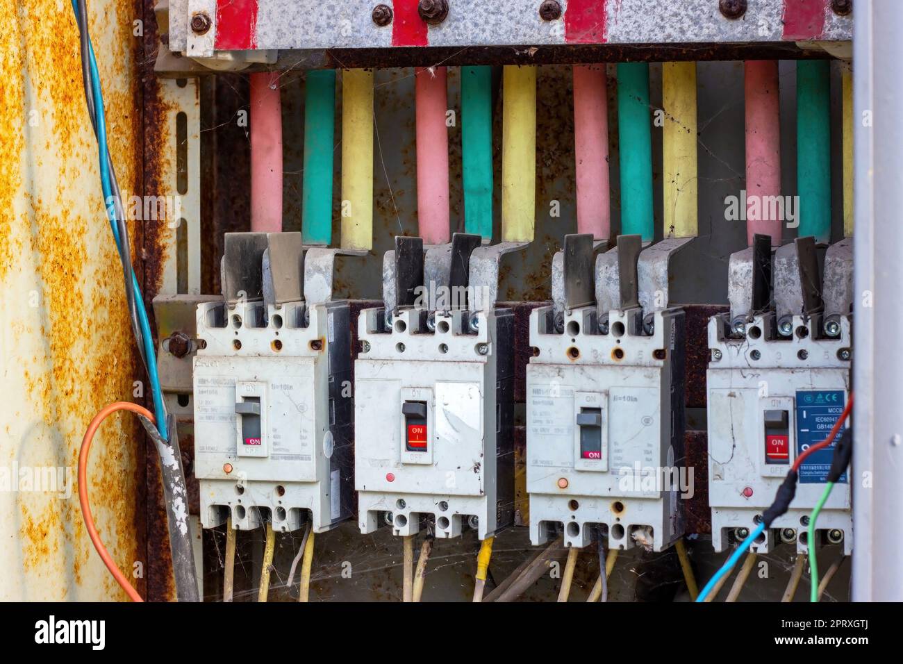 DUSHANBE, TAGIKISTAN - 12 AGOSTO 2022: Molte vecchie scatole fusibili elettriche arrugginite con cavi elettrici. Foto Stock