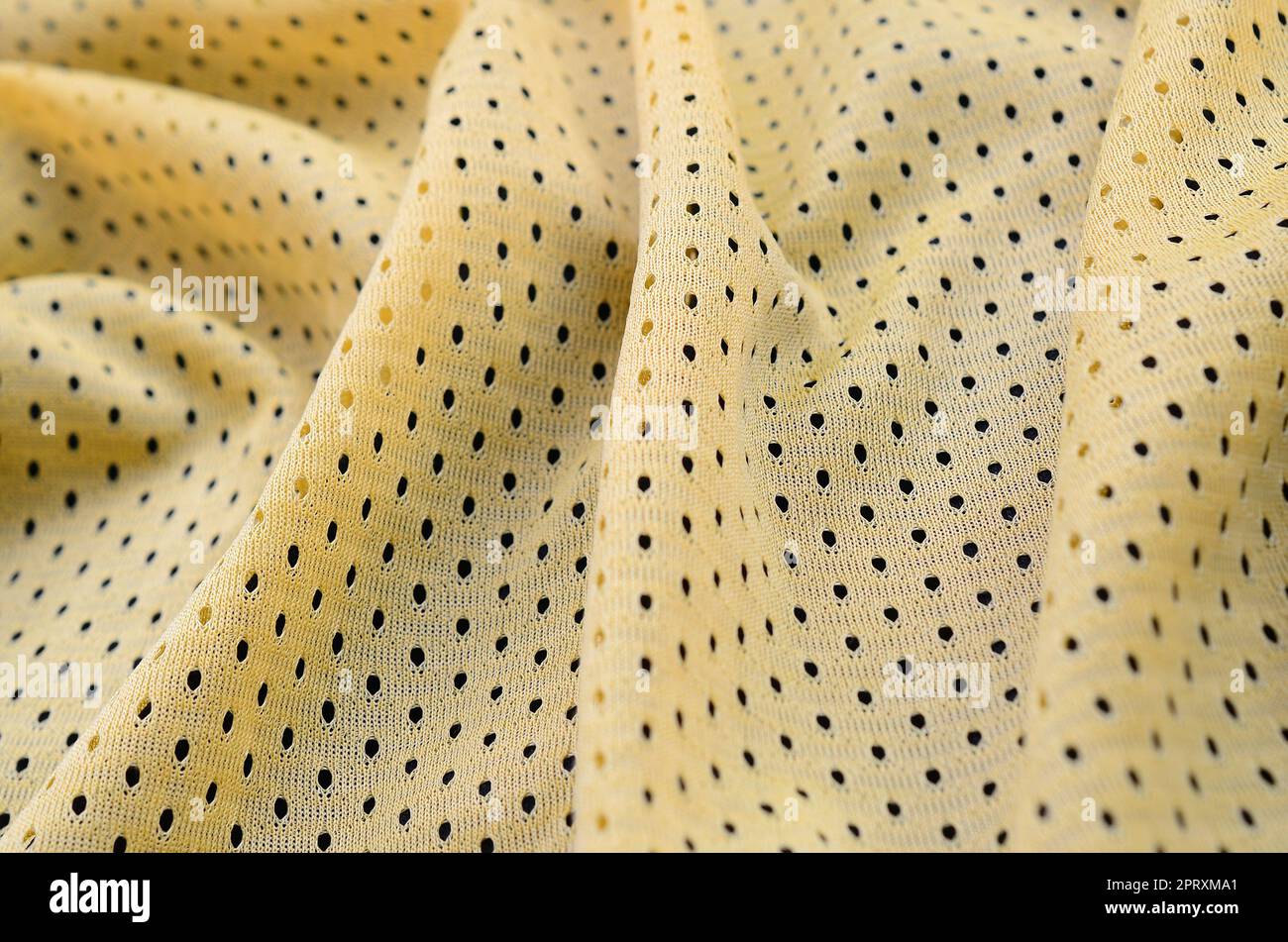 Maglia sportiva gialla tessuto texture e sfondo con molte pieghe Foto Stock