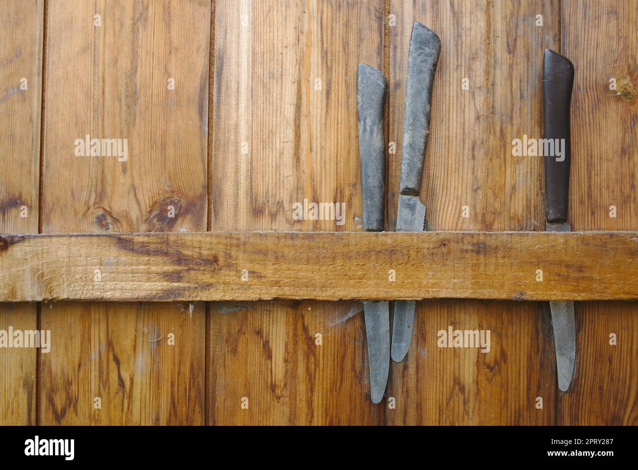 coltelli immagazzinati all'interno della porta a capannone, pronti per la mietitura, a un'assegnazione. Foto Stock