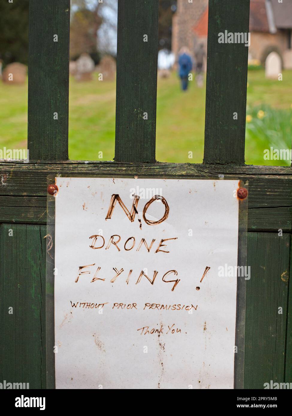 Un avviso che chiede alle persone di non far volare i droni è fissato a un cancello della chiesa nel Suffolk Foto Stock