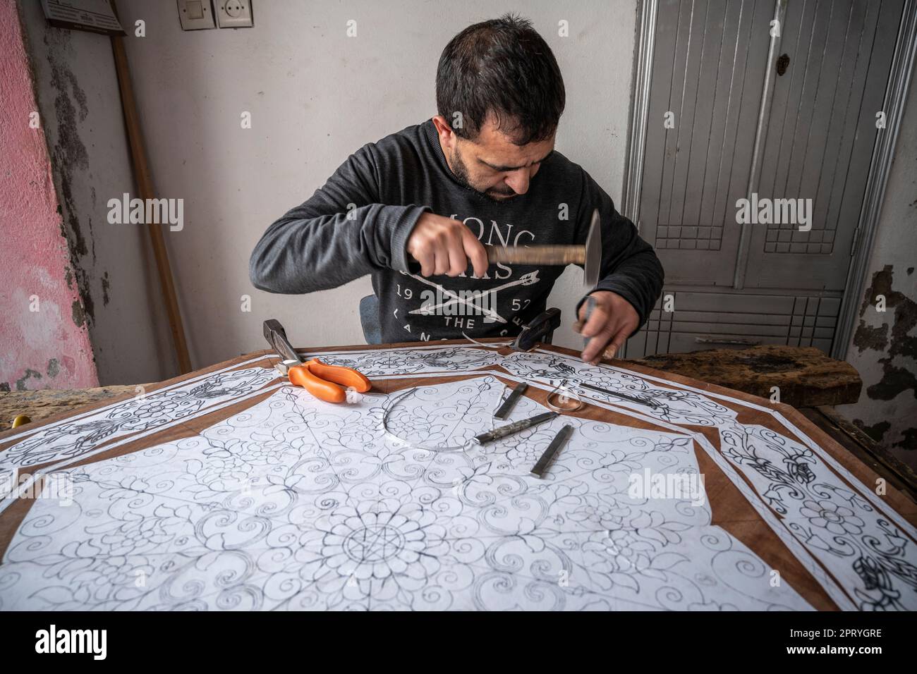 Ornamenti di scultura artigianale su un tavolo di legno con martello e scalpello. Foto Stock