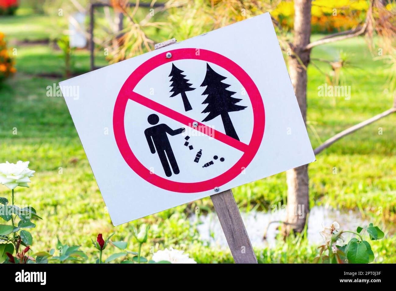 Non cucciolate incrociate segno rosso e bianco sullo sfondo verde della foresta. La notifica di divieto di lancio dei rifiuti. Foto Stock