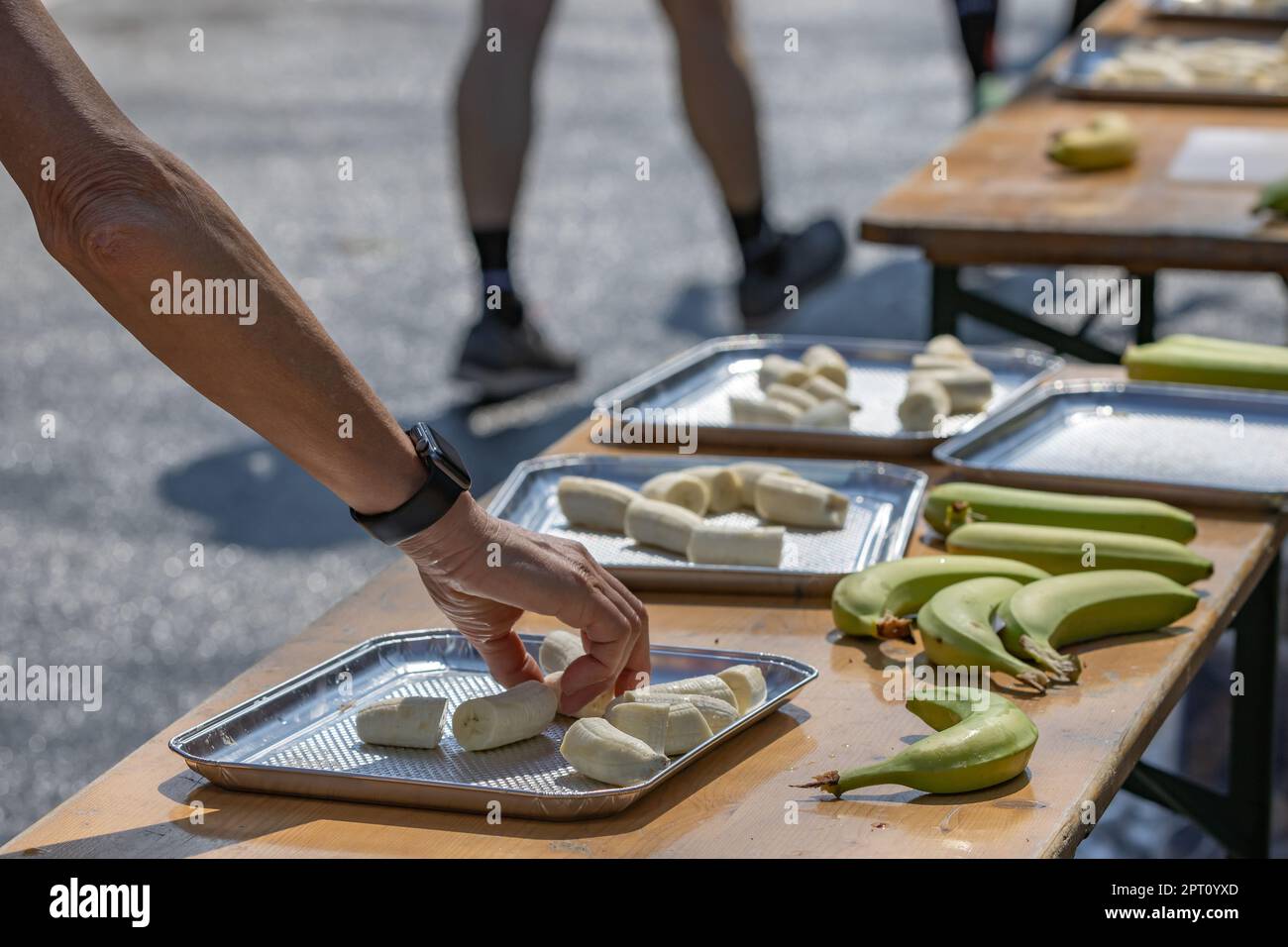 il corridore della maratona afferra una banana allo stand gastronomico della maratona di amburgo Foto Stock