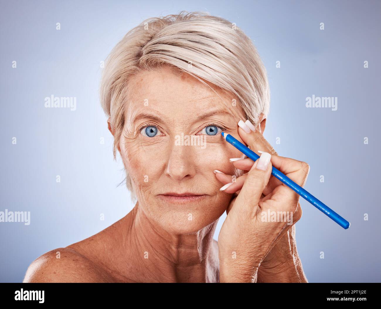 Bellezza, trucco e donna matura con matita eyeliner per gli occhi blu su sfondo studio. Salute, cosmetica e cura della pelle, un ritratto di senio bello Foto Stock