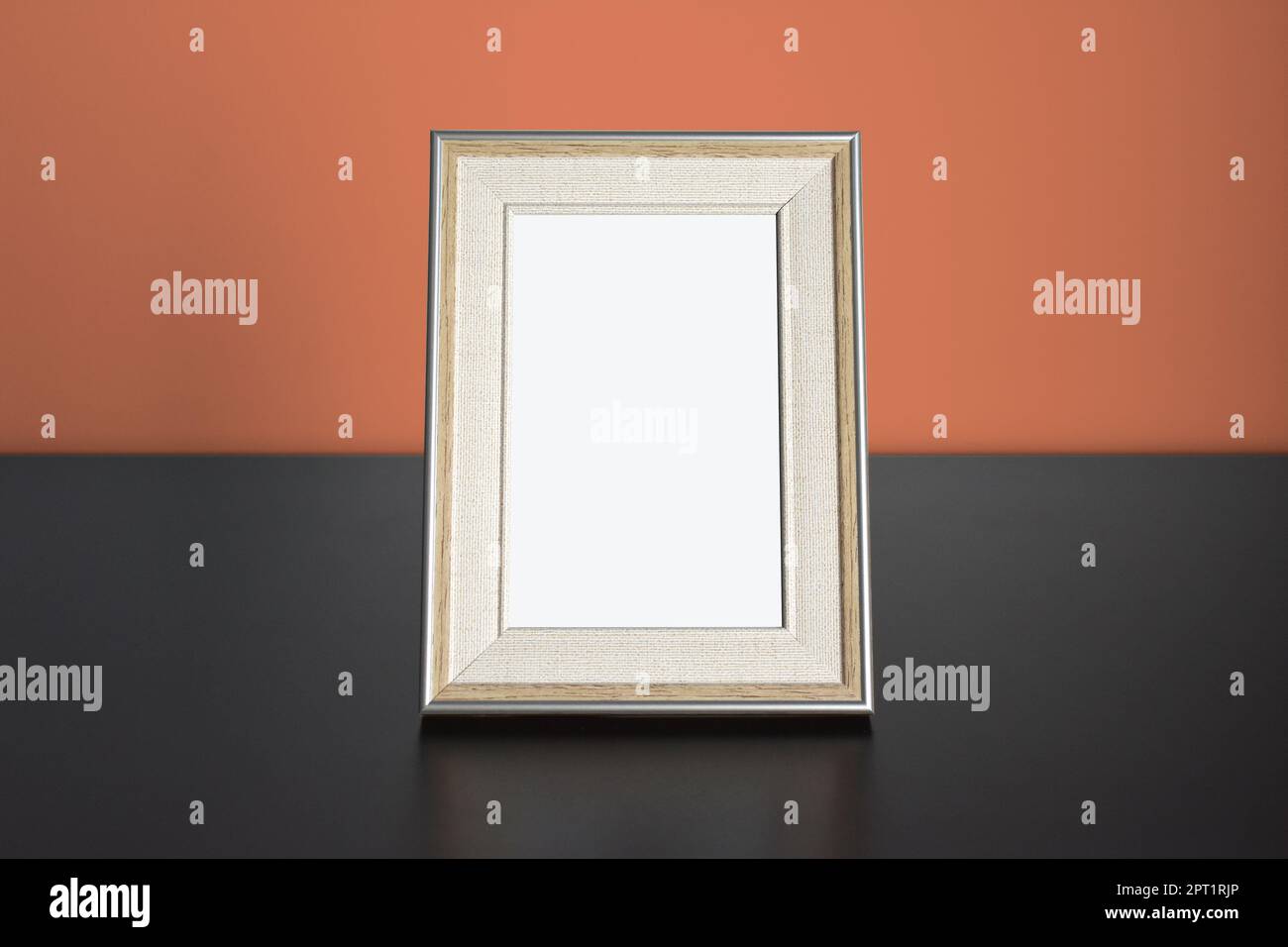 Foto cornice immagine Mockup su tavolo con parete arancione Foto Stock