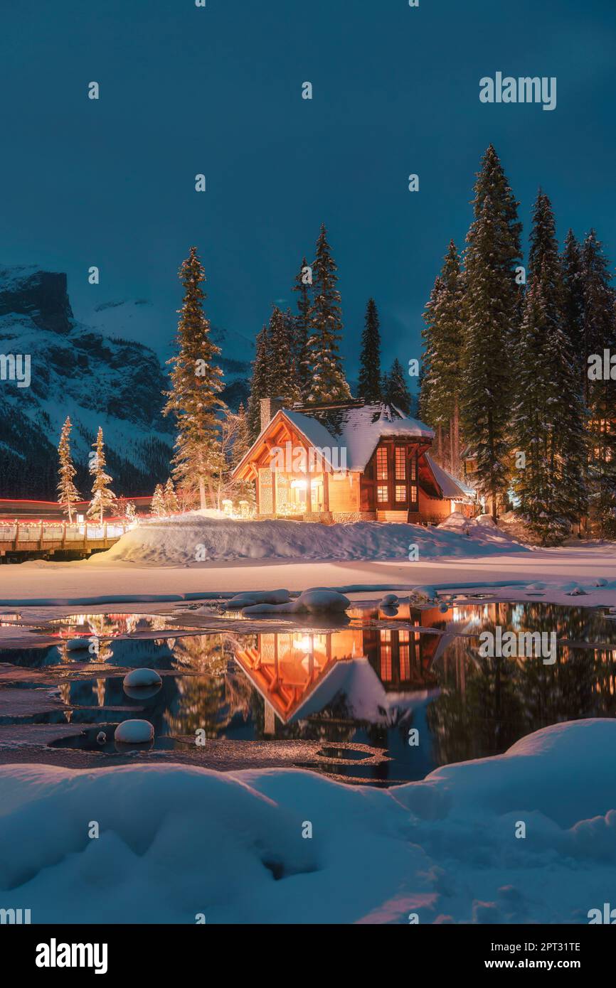 Splendida vista sul lago Emerald, con Lodge in legno che risplende nella pineta innevata in inverno al parco nazionale di Yoho, Alberta, Canada Foto Stock