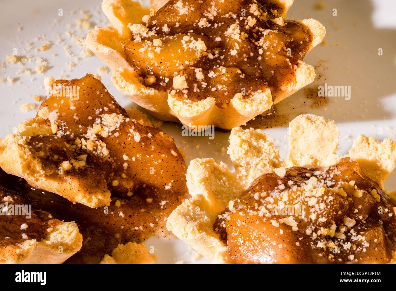 100mm Macro di 2 tartine di mele, crostate piccole, torta piccola, briciole, crosta di shortbread e spezzate a pezzi. Foto Stock