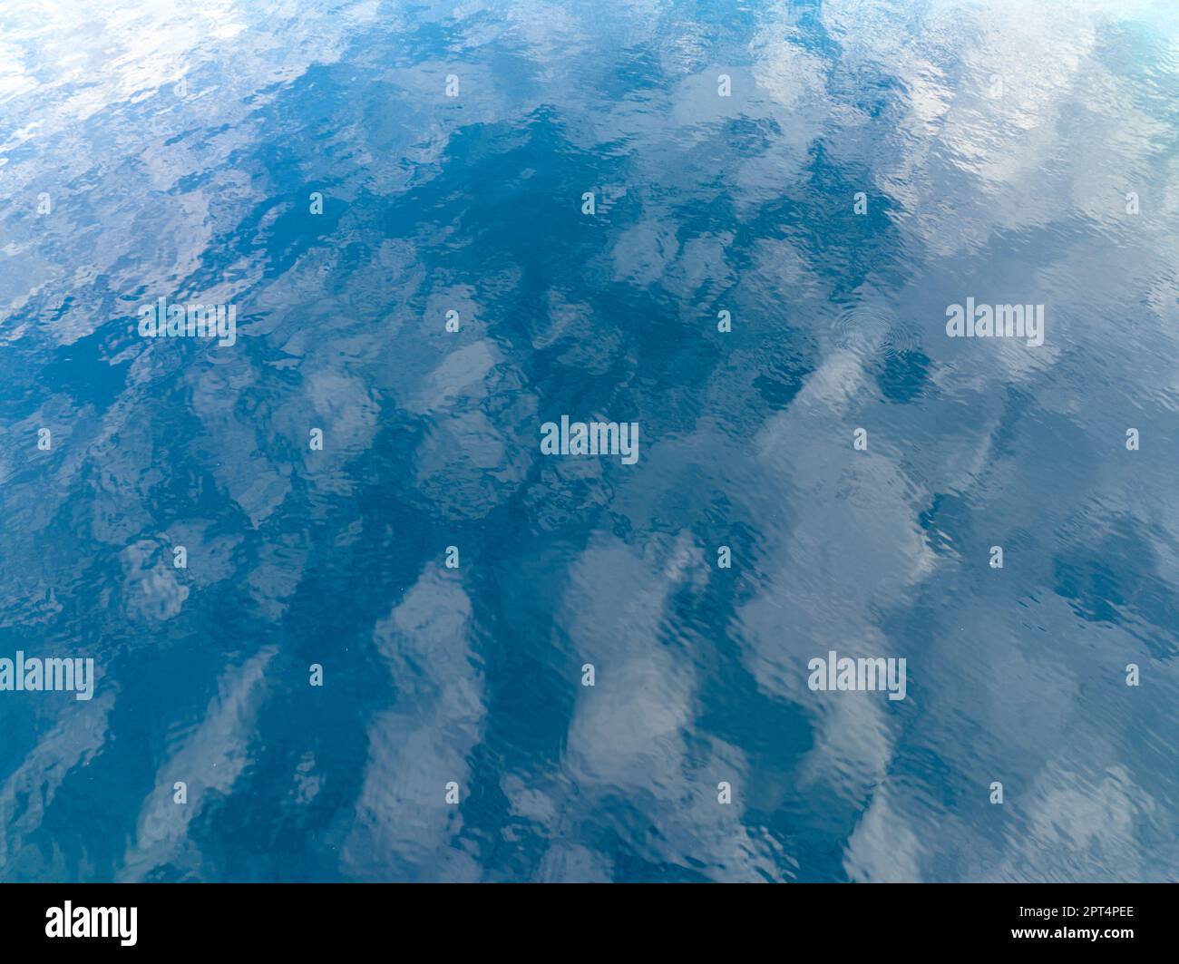 Le nuvole si riflettono nella calma superficie dell'Oceano Pacifico tropicale. Foto Stock