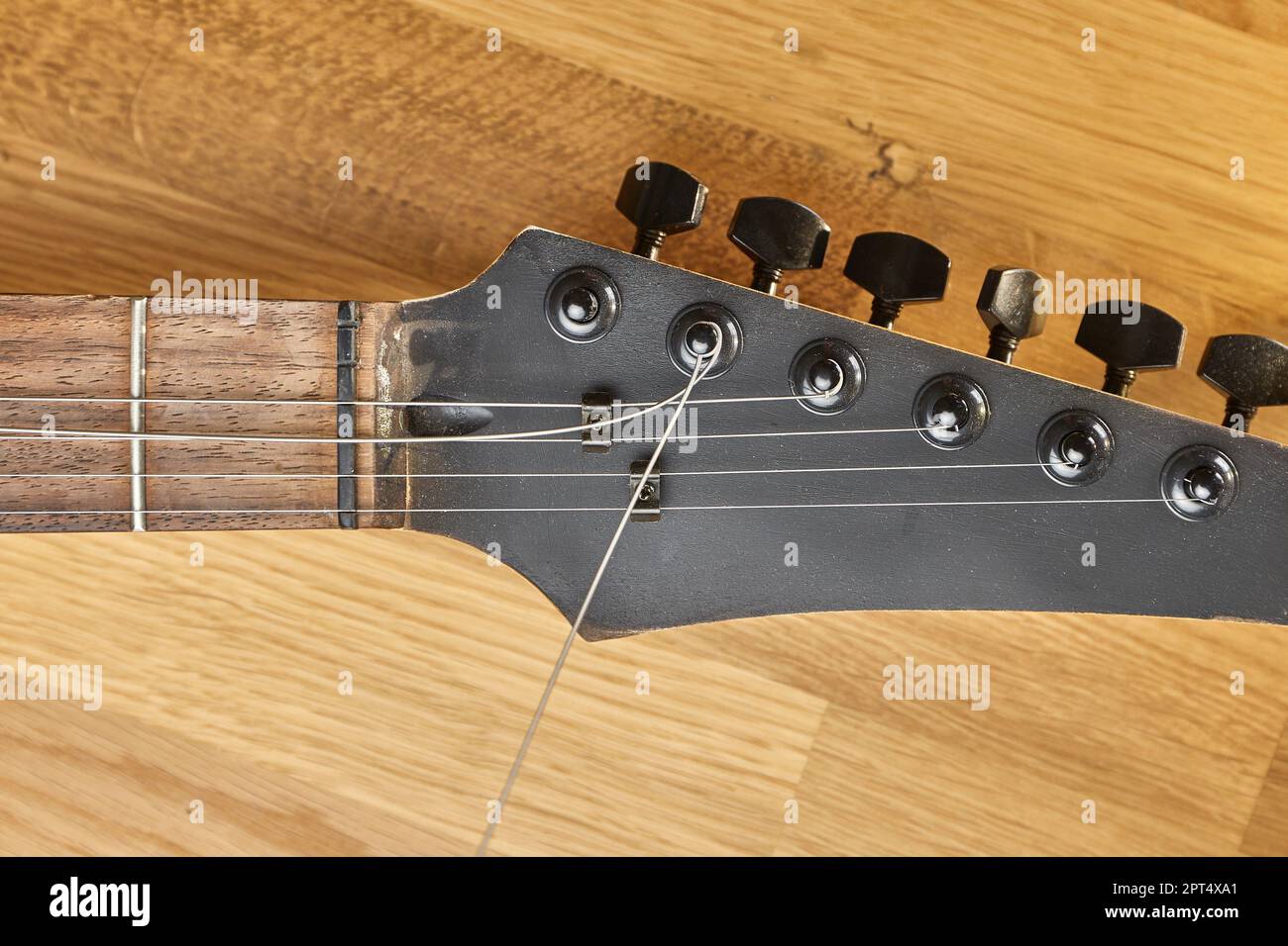 Mettere una nuova stringa su una chitarra elettrica, cambio di stringa e sintonizzazione Foto Stock