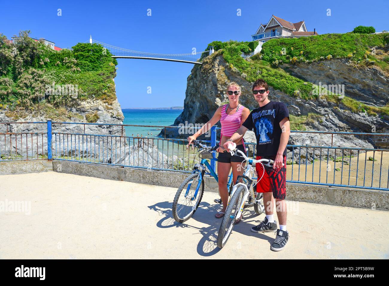 Coppia giovane con le biciclette da Towan Beach, Newquay Cornwall, England, Regno Unito Foto Stock