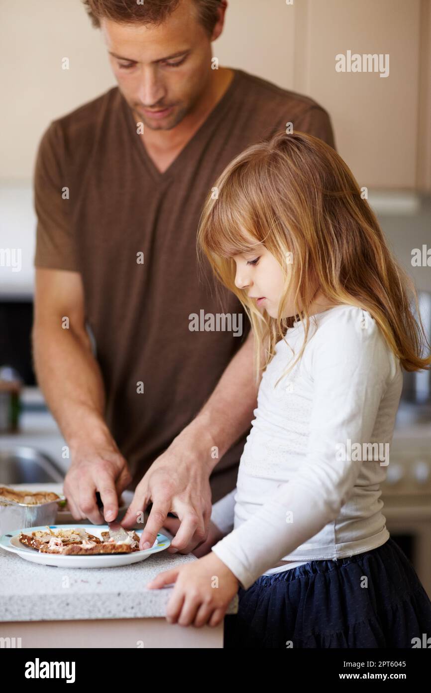 Instillando buone abitudini alimentari. Una bambina che fa colazione con suo padre Foto Stock