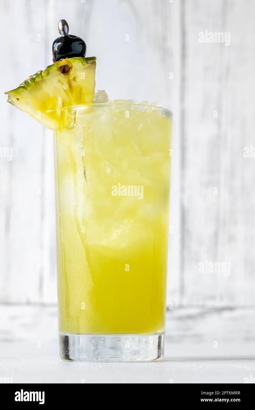 Bicchiere di cocktail Chartreuse Swizzle guarnito con spicchio di ananas Foto Stock