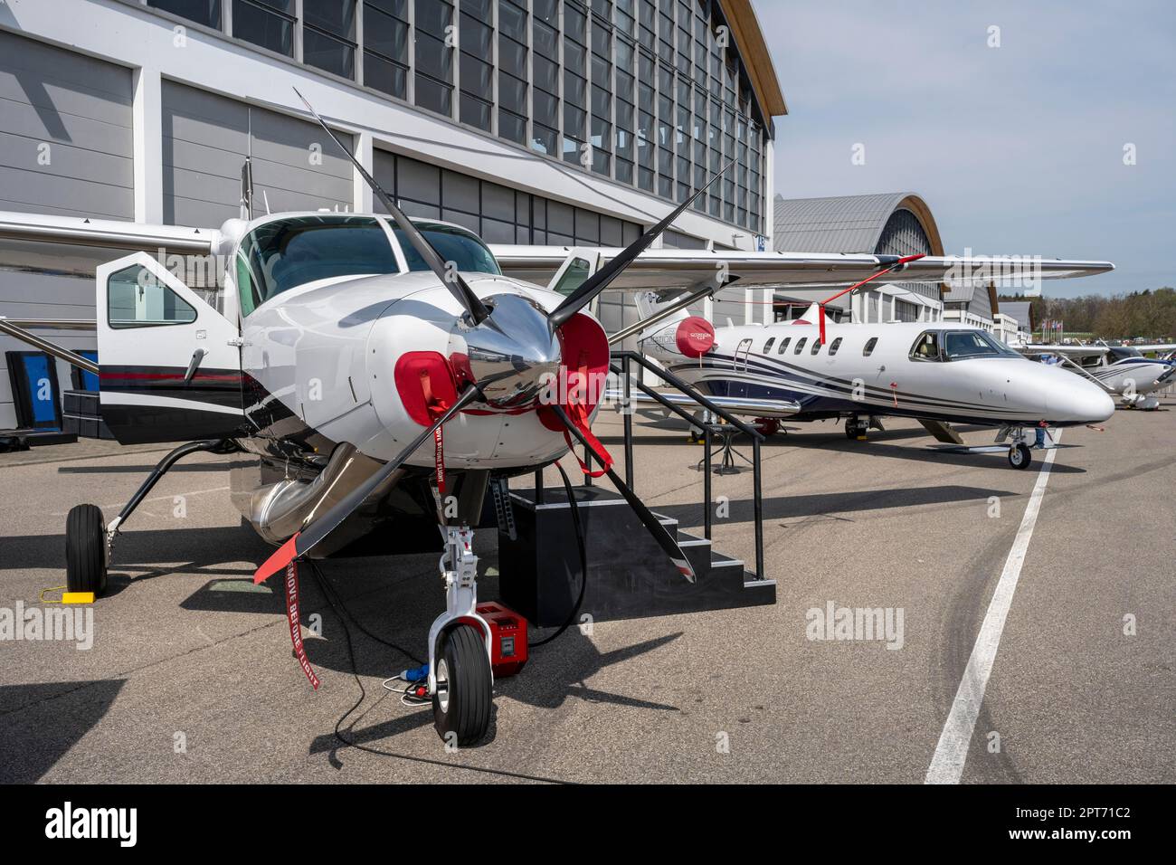 I business jet sono allineati di fronte alle sale espositive durante la fiera internazionale dell'aviazione generale AERO Friedrichshafen 2023 Foto Stock