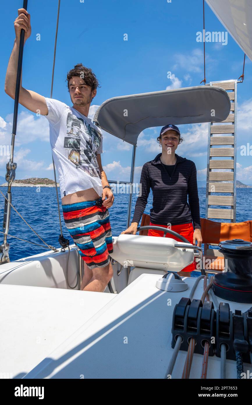 Marinaio, skipper al volante, giovane donna e giovane uomo a vela, vela su un catamarano a vela, Dodecaneso, Grecia Foto Stock