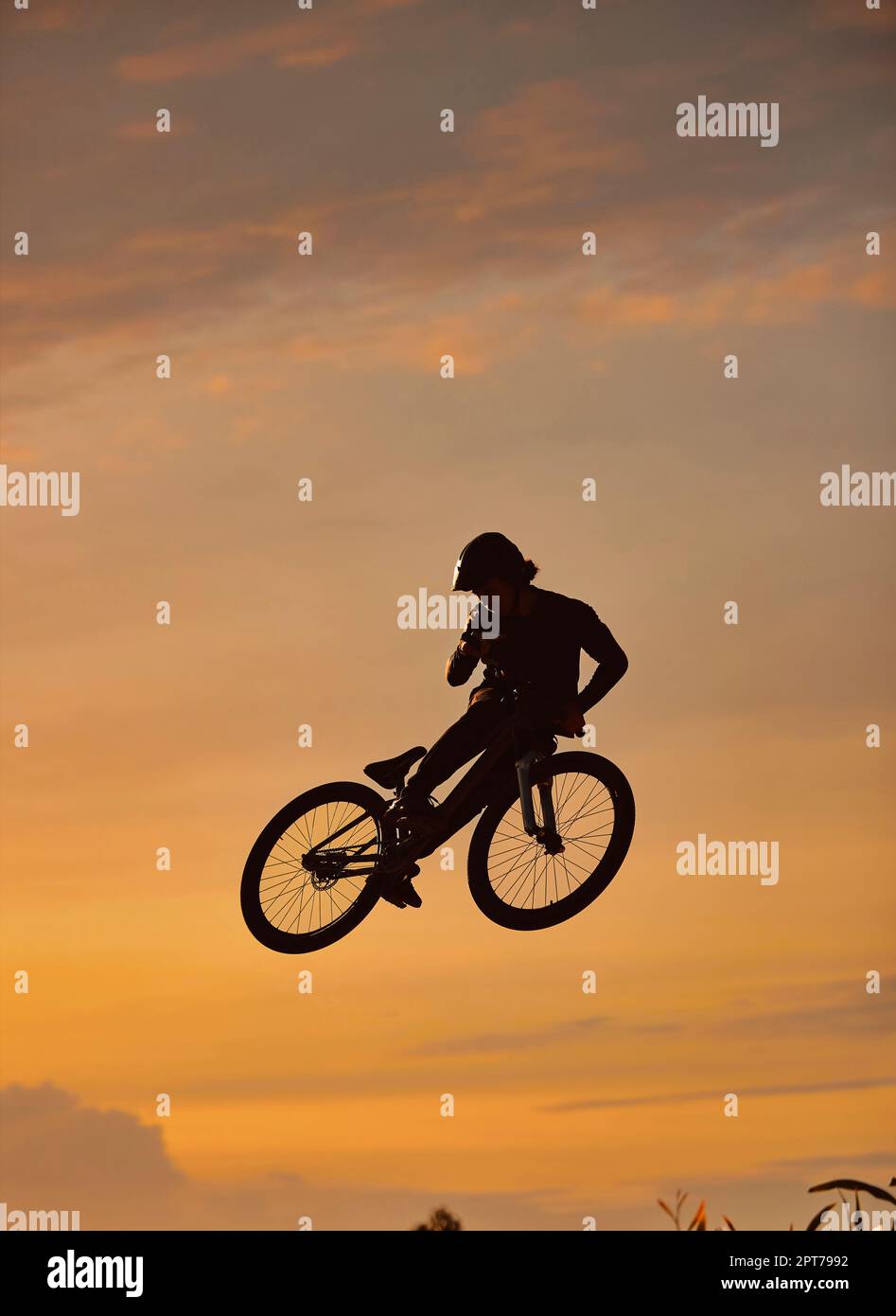 Mountain bike, ciclista e fitness jump al tramonto nella natura della campagna del Colorado in allenamento, esercizio fisico o allenamento. Pericolo, sport estremi BMX o. Foto Stock