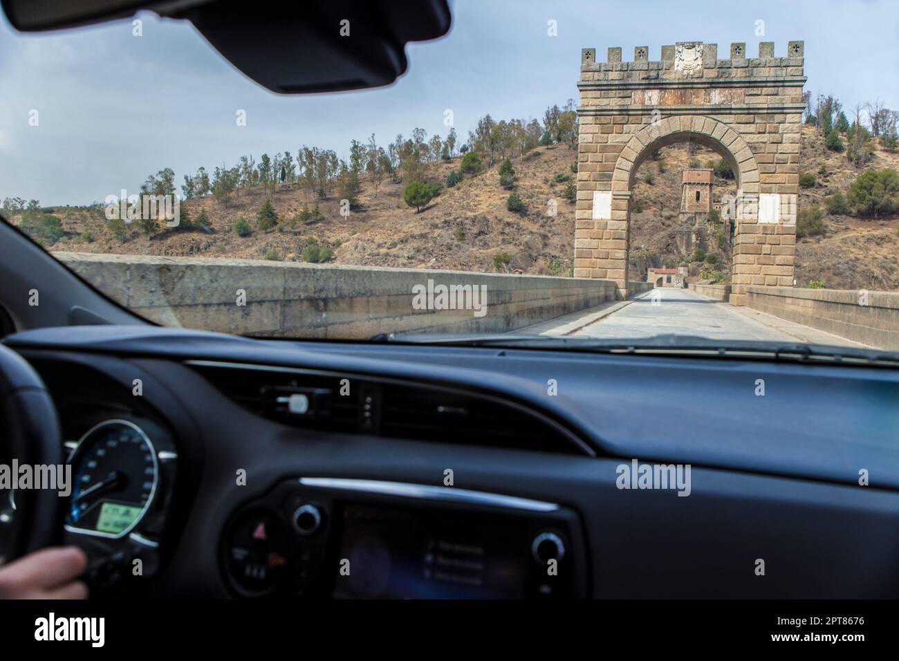 Attraversando il ponte romano dell'Alcantara ancora in uso dal II secolo a.C. Vista dall'interno dell'auto Foto Stock