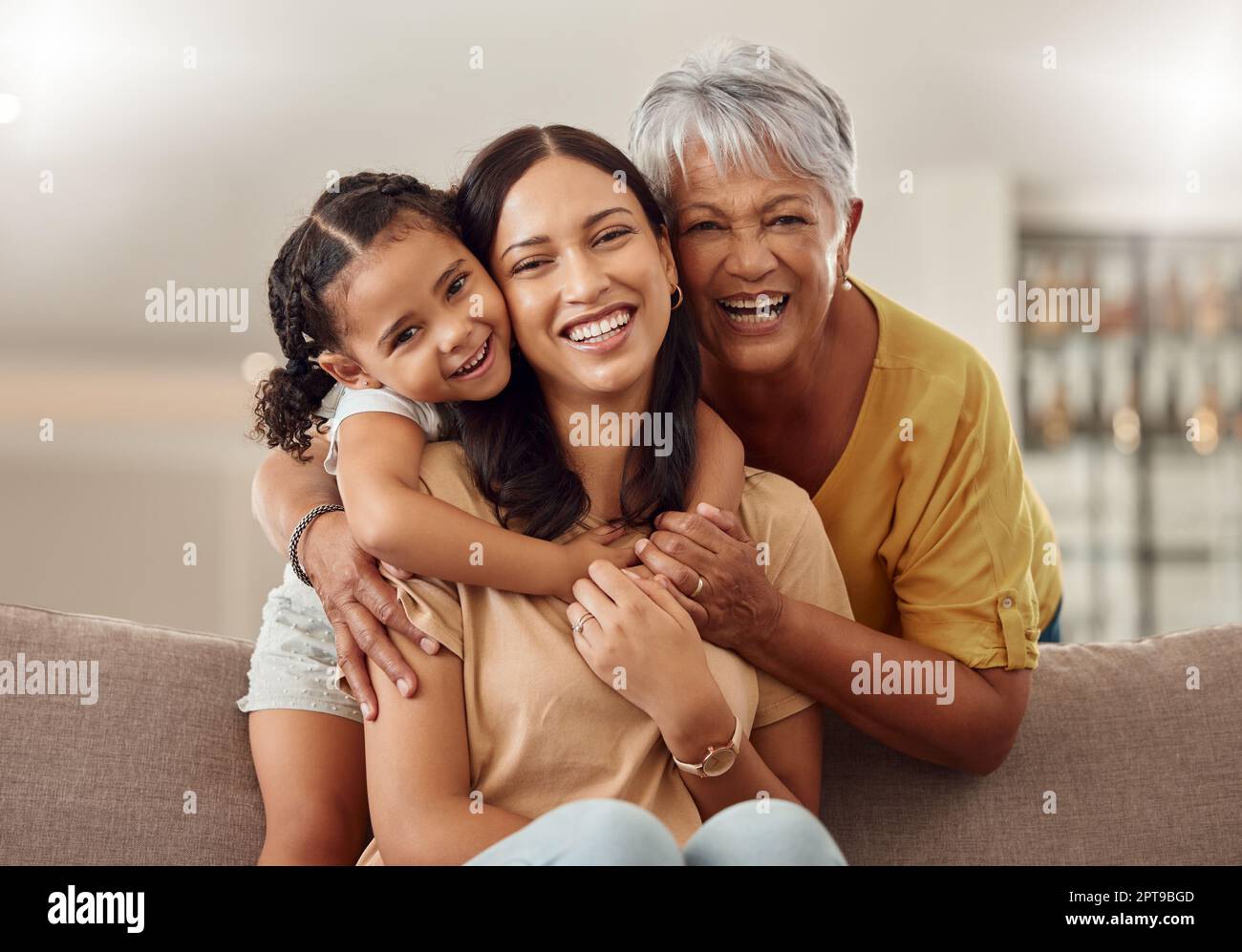 Nonna, mamma e bambino abbracciano in un ritratto per la giornata delle madri su un divano di casa come una famiglia felice in Colombia. Sorriso, mamma e donna anziana amano abbracciarsi Foto Stock