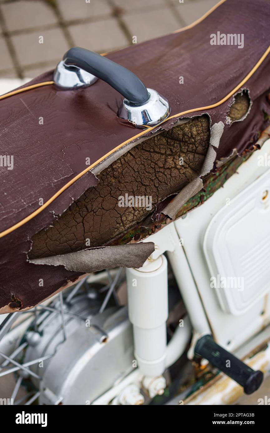 Coprisella marrone per moto in pelle sintetica (PVC o PU), strappata per vedere la spugna all'interno. Foto Stock