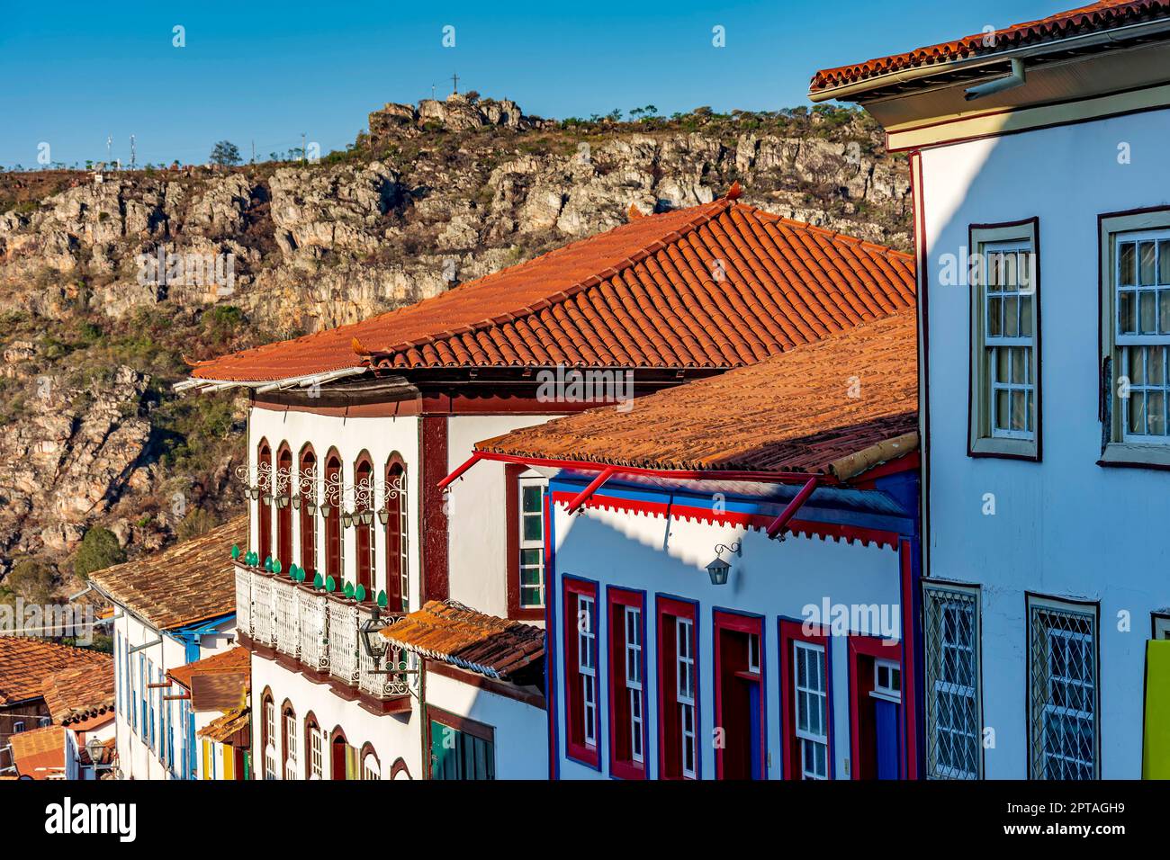 Dettaglio delle strade e delle case in stile coloniale nella città vecchia e storica di Diamantina a Minas Gerais con le montagne sullo sfondo durante il Foto Stock