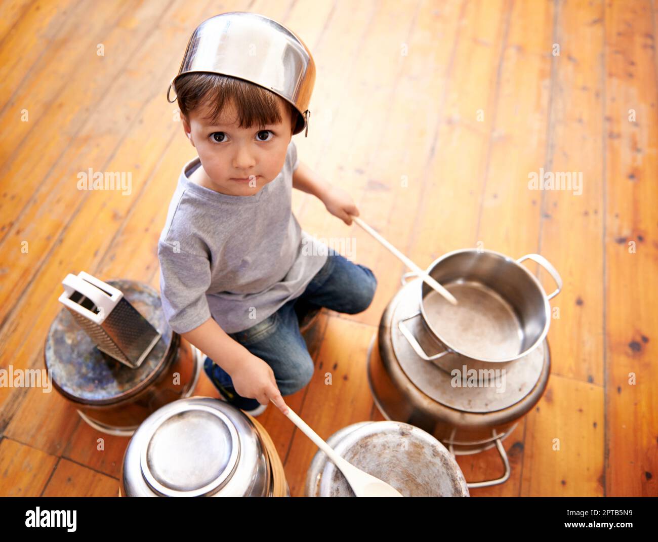 Qualsiasi richiesta da parte del pubblico. un adorabile ragazzino che beve su pentole e padelle Foto Stock