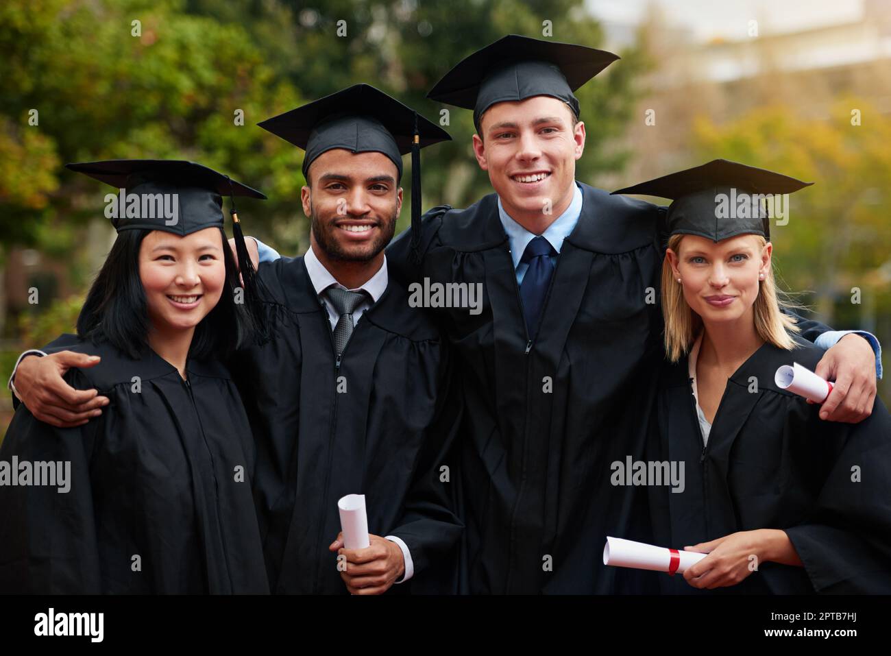 Le strade difficili portano spesso a splendide destinazioni. Un gruppo di laureati in CAP e abito e titolari dei loro diplomi Foto Stock