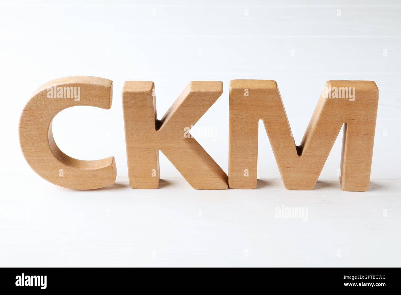 Abbreviazione CKM (Customer Knowledge Management) composta da lettere su tavolo di legno bianco Foto Stock